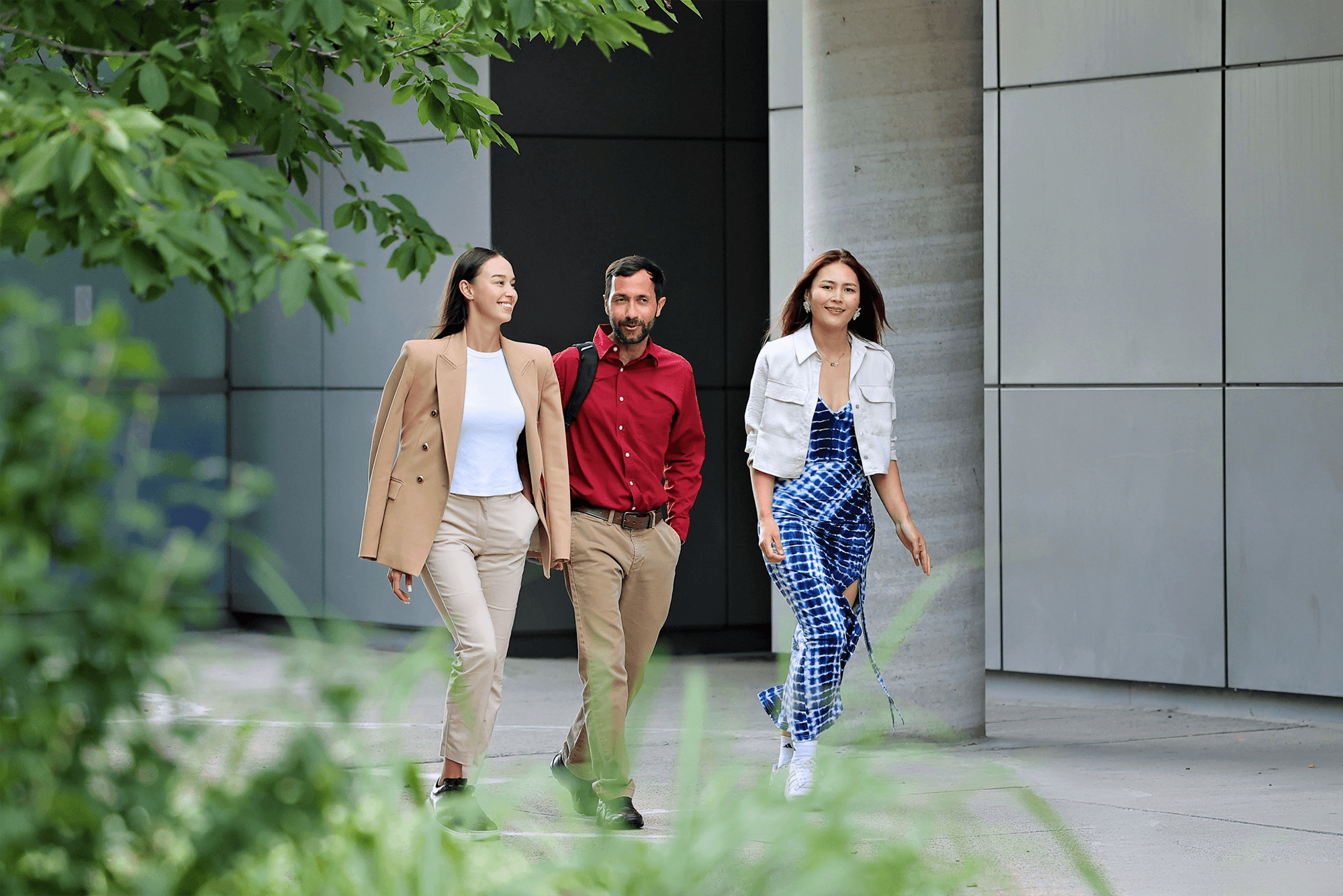 Three individuals walking and having a conversation outside UNF campus