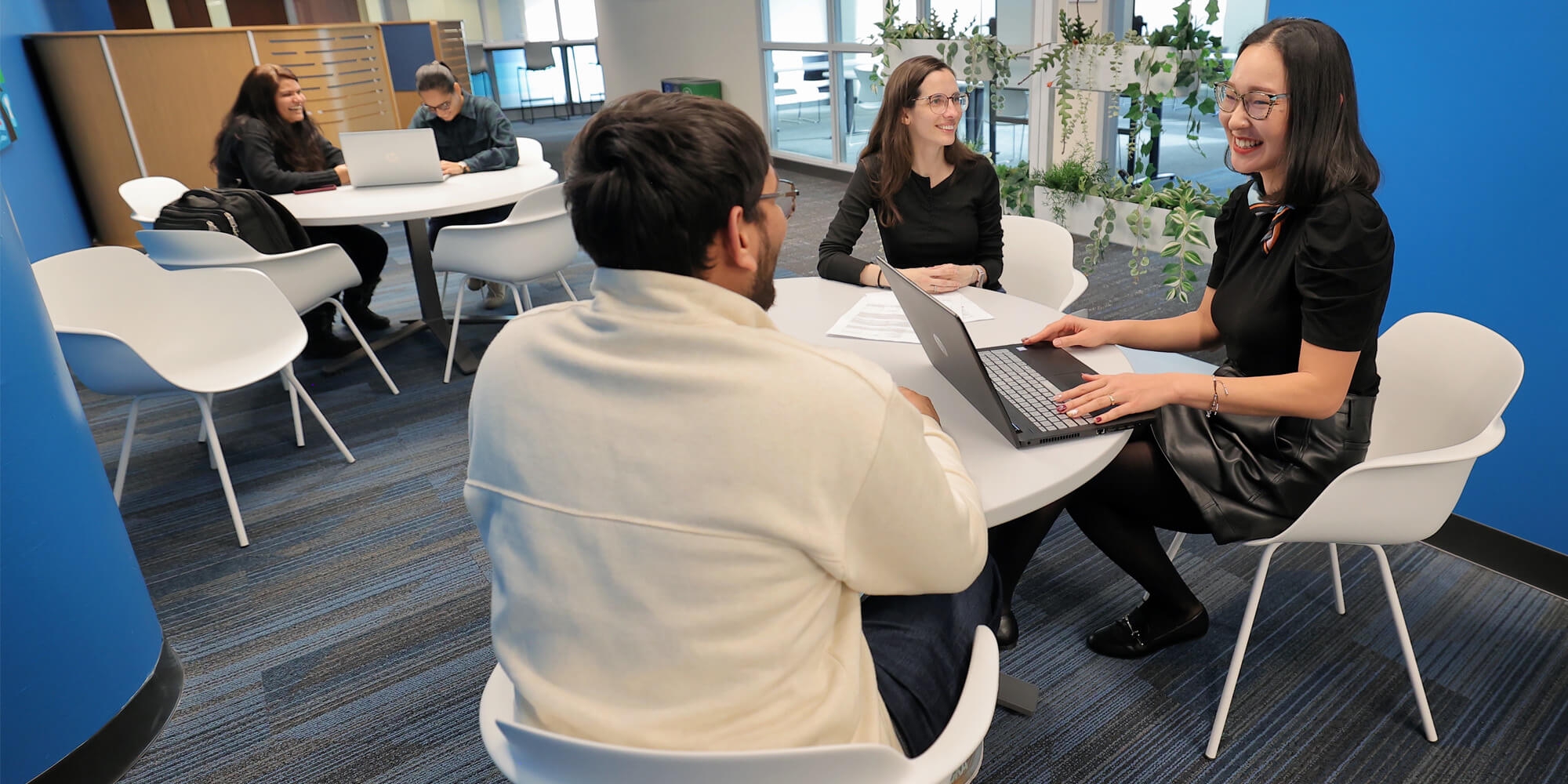 A group of individuals with laptop engaged in a discussion in a round table inside UNFC campus