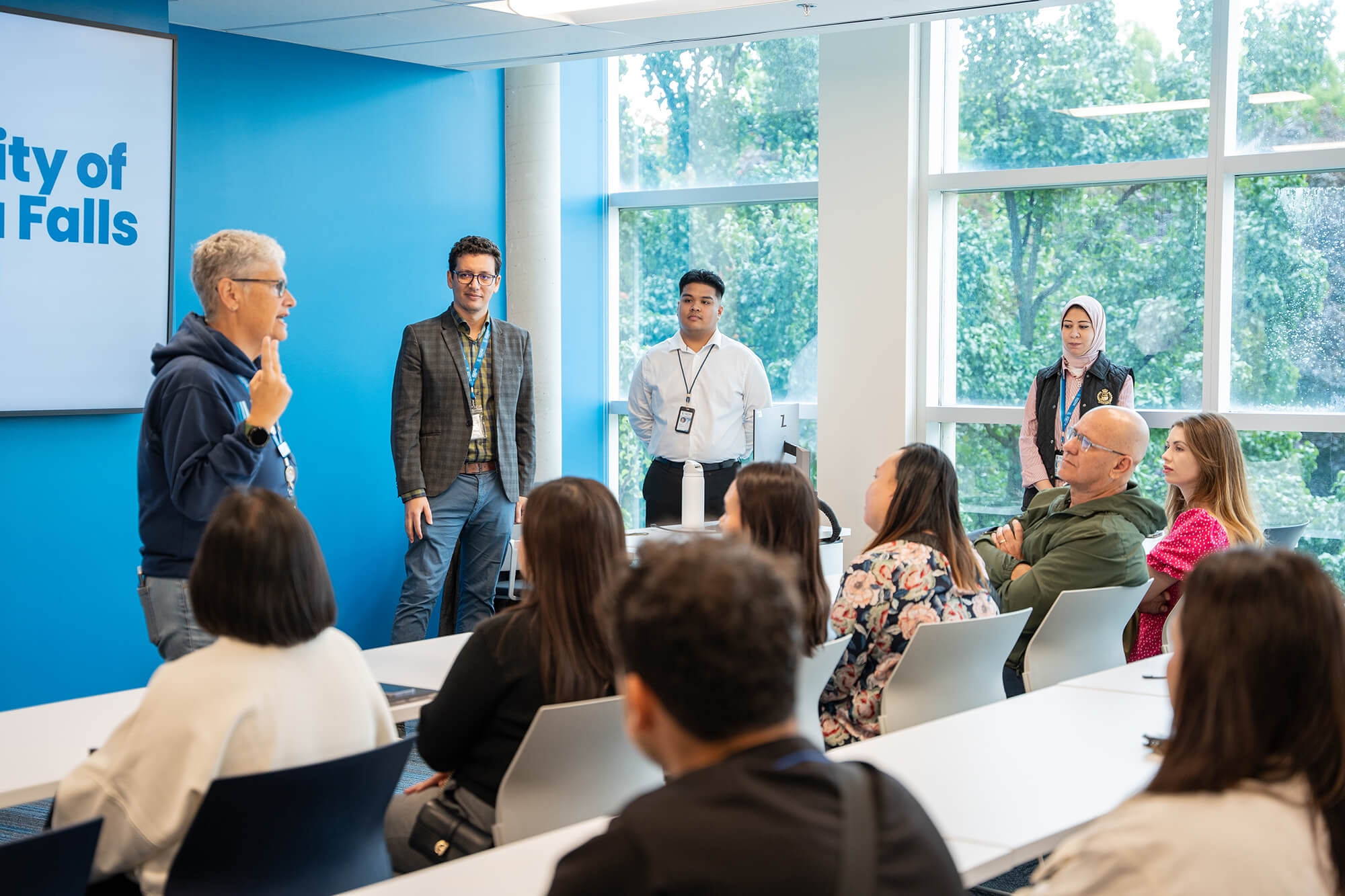 A diverse group of individuals attentively listening to a speaker in a classroom setting