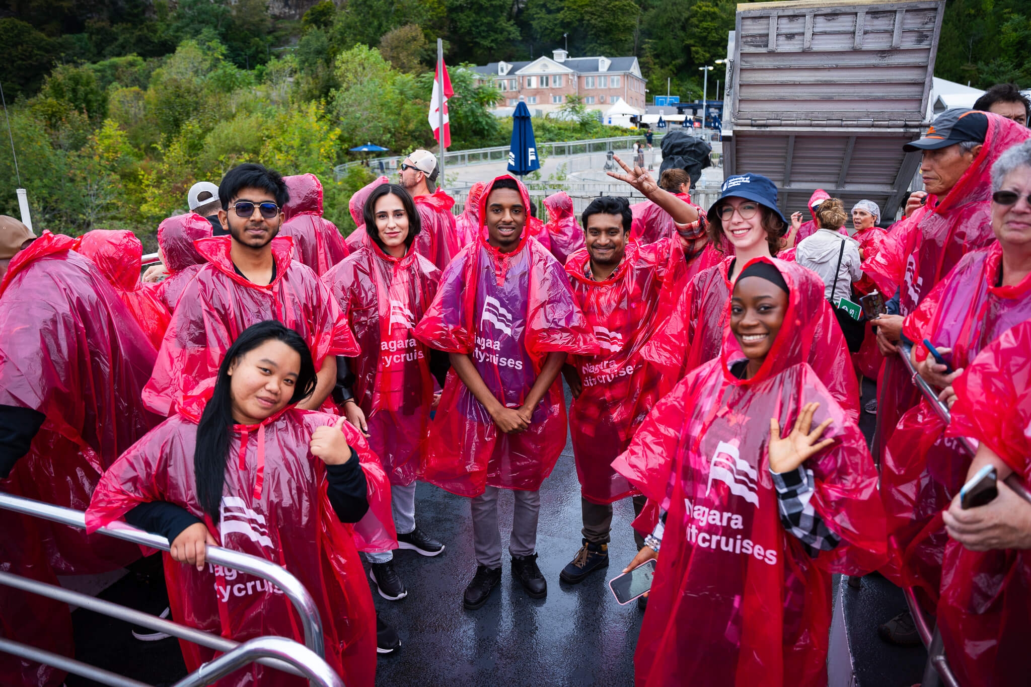 A diverse group of individuals wearing rain coats and enjoying the Niagara cruise