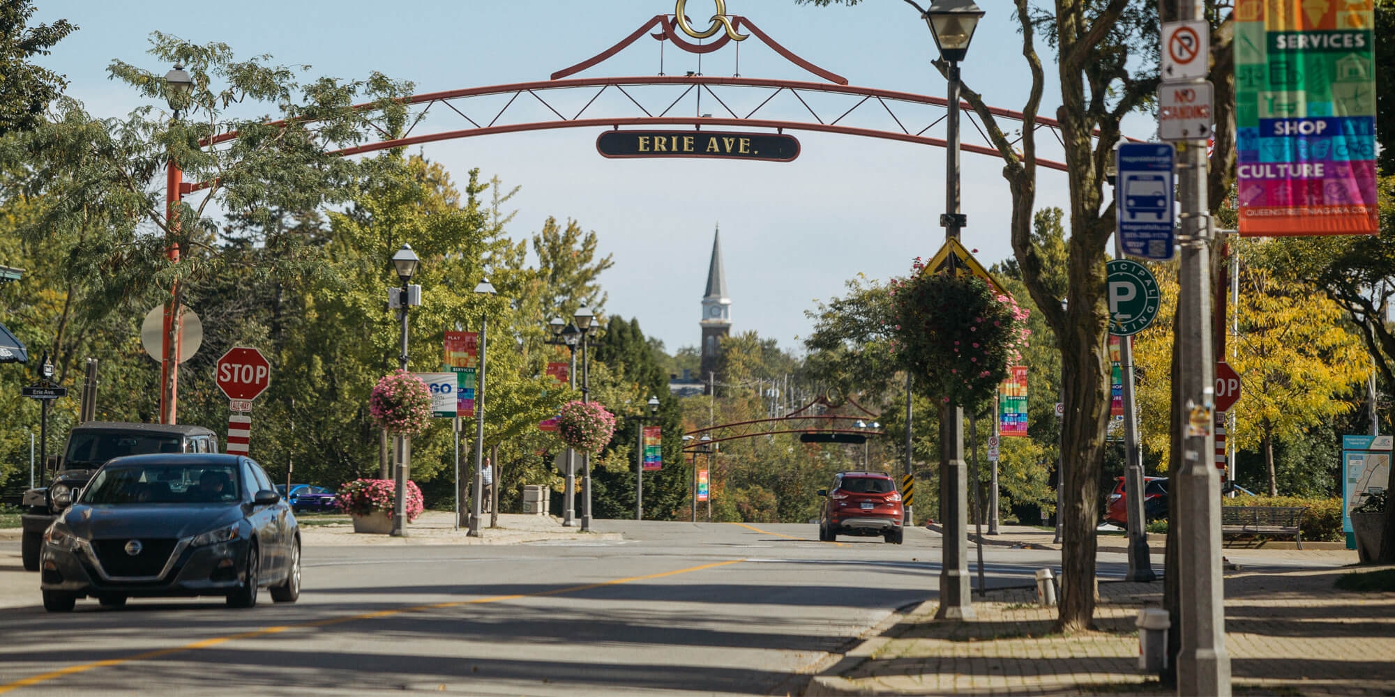 A road marked by a "Erie Ave" sign, with a car traveling down the street, illustrating a vibrant community atmosphere