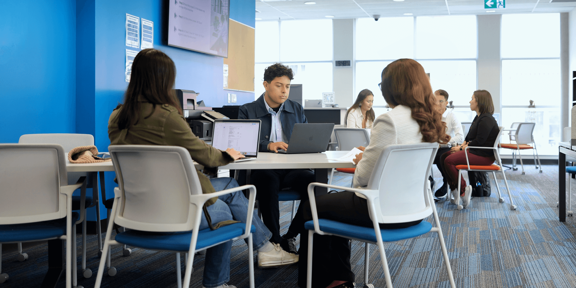 A group of students with laptops studying inside UNF campus