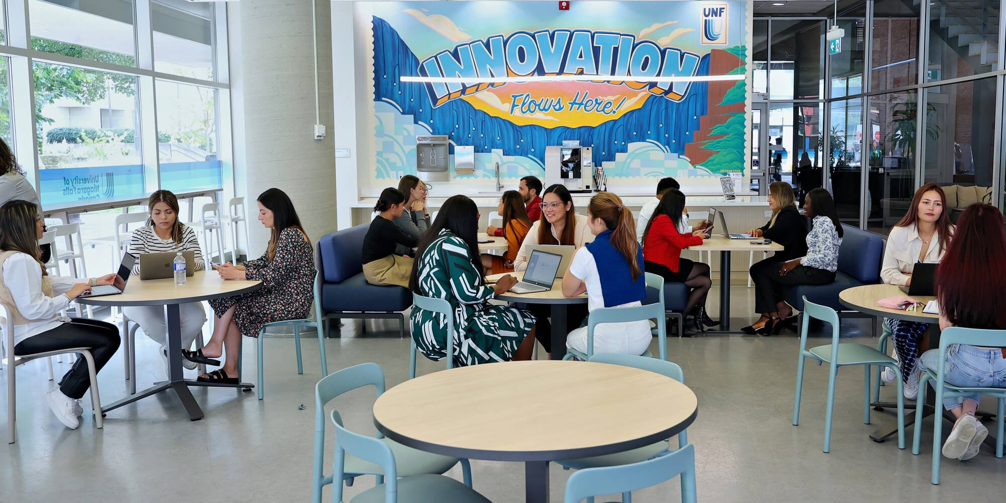 A group of individuals with laptops studying in a common area inside UNFC campus