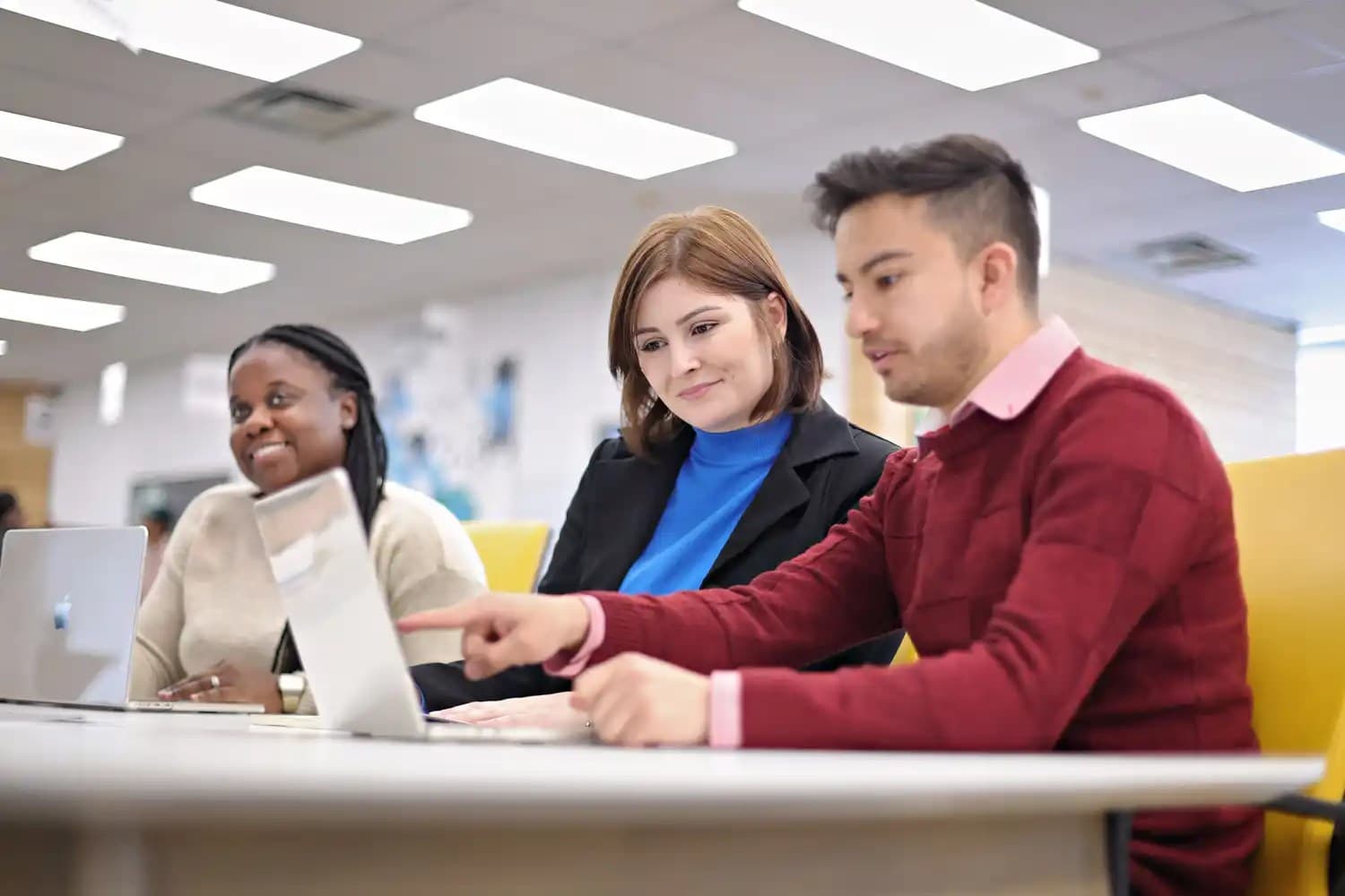 UNF students in a classroom and looking at a laptop screen