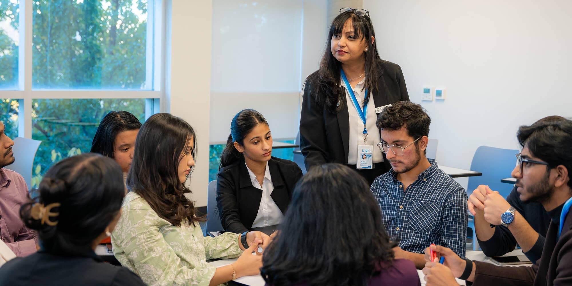 Several people gathered around a table, actively discussing and sharing ideas in a friendly atmosphere