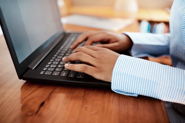 Person typing on a laptop keyboard