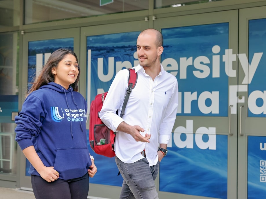 Two students walking outside university building