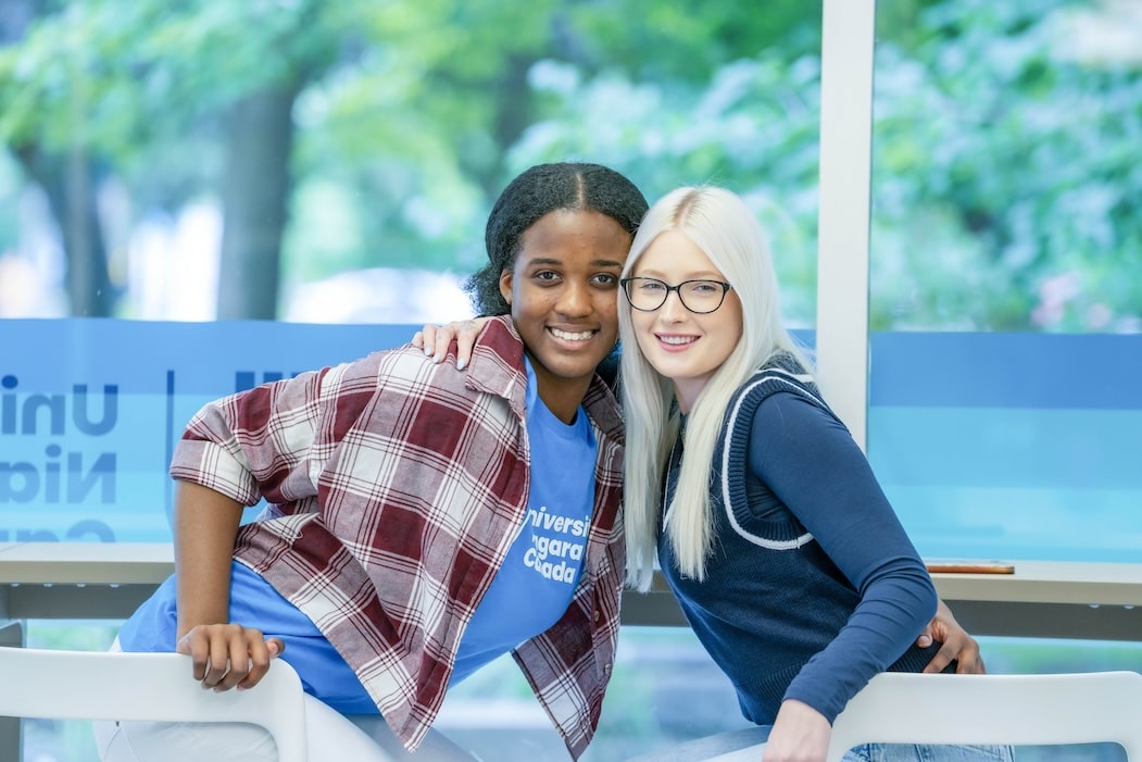 Two young women at a table, sharing a moment together