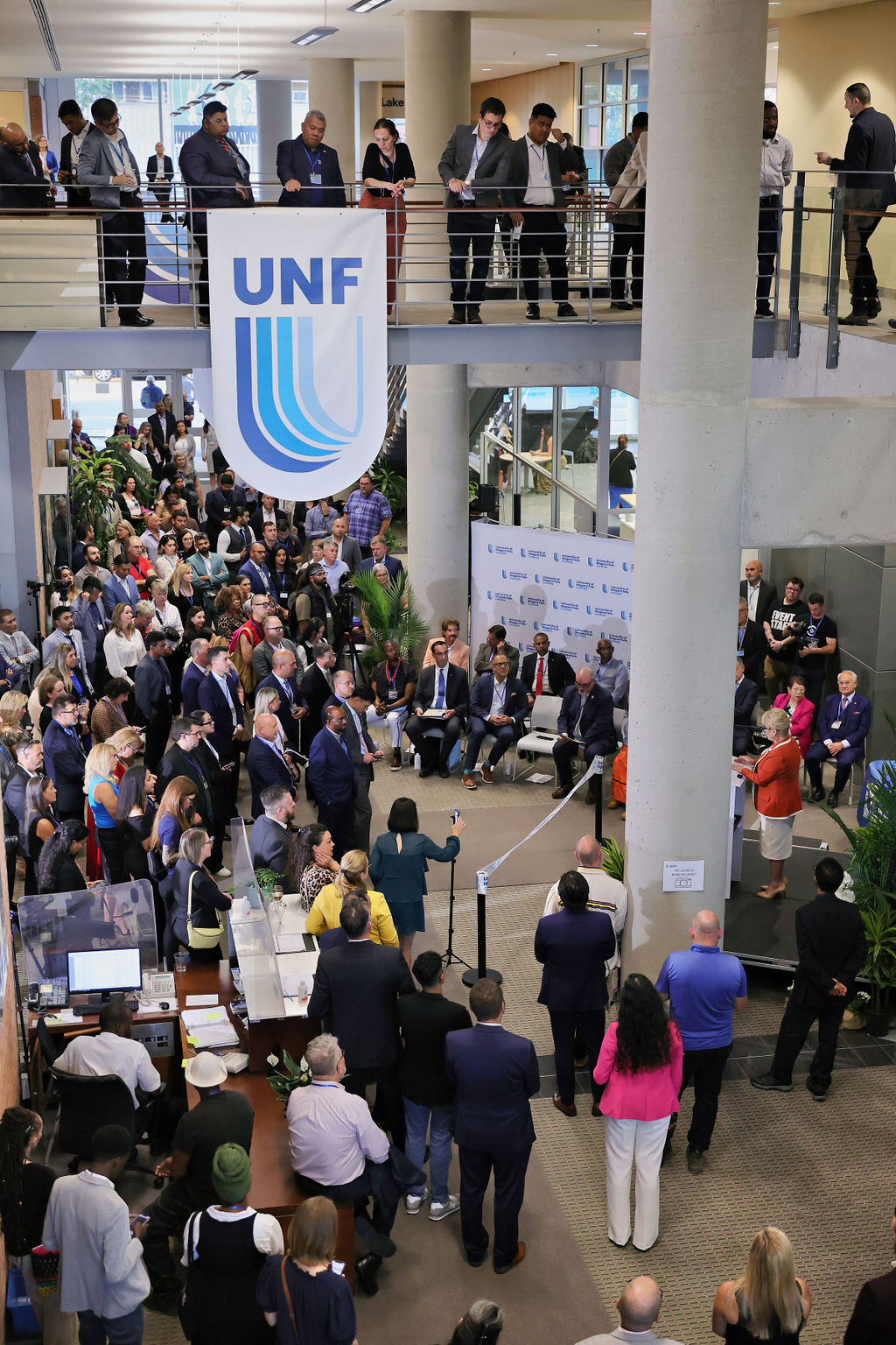 Several people gathered together, cutting a ribbon at a ceremonial event, marking the official opening of a new venture.