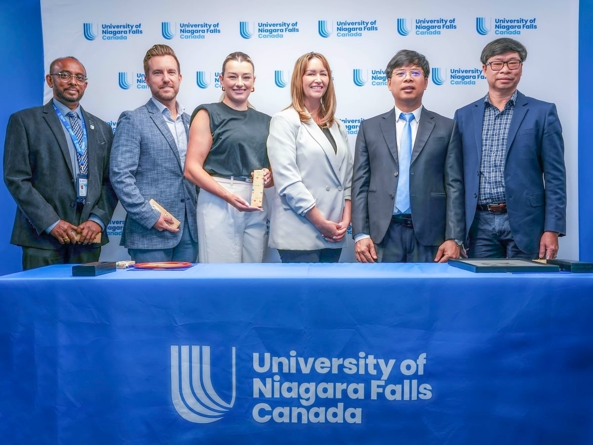 Group of people posing for a photo after signing an agreement