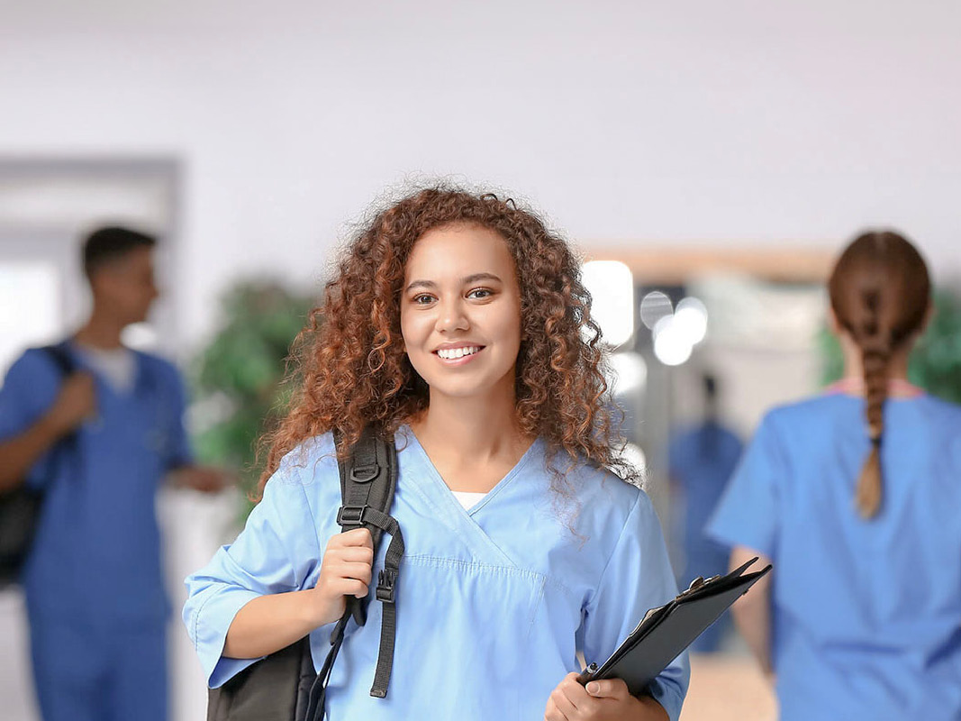 Group of healthcare professionals in uniform gathered in a corridor at a medical facility.