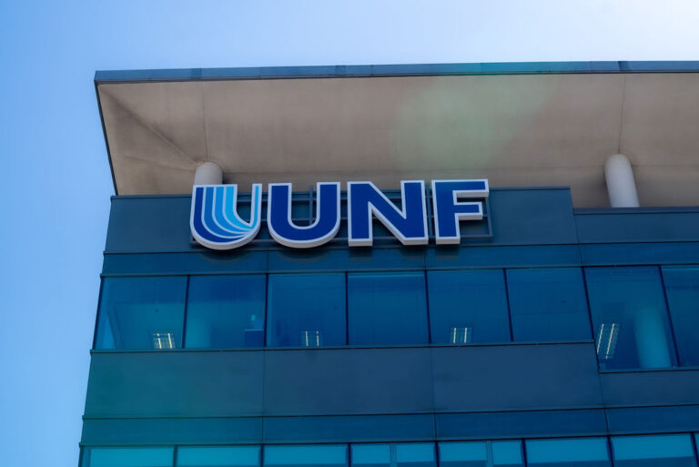 A blue sky in the background with the corner of a building showing the letters UNF on a sign.