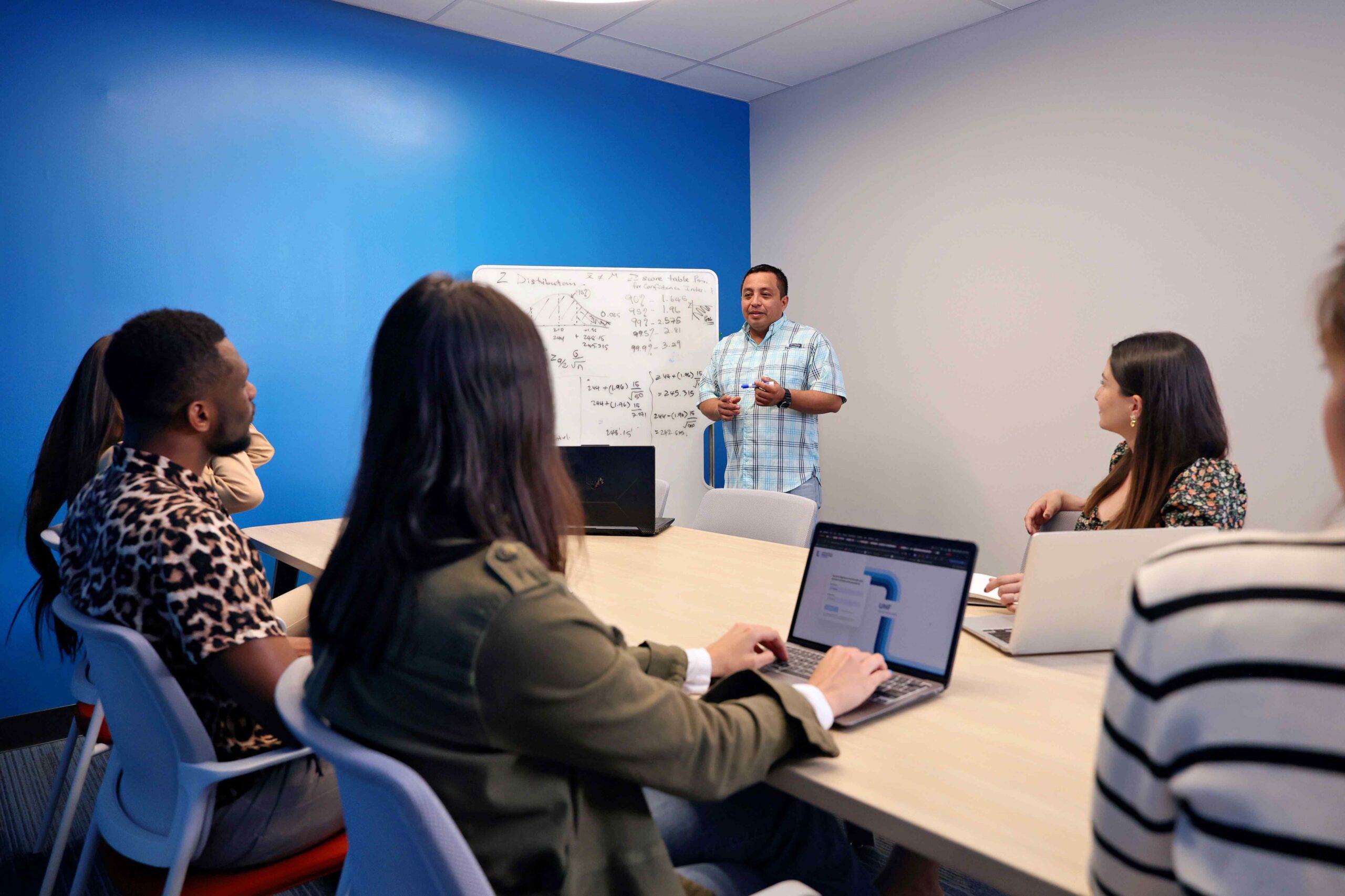 A man presents to an audience, engaging them with his speech and visual aids in a professional setting.