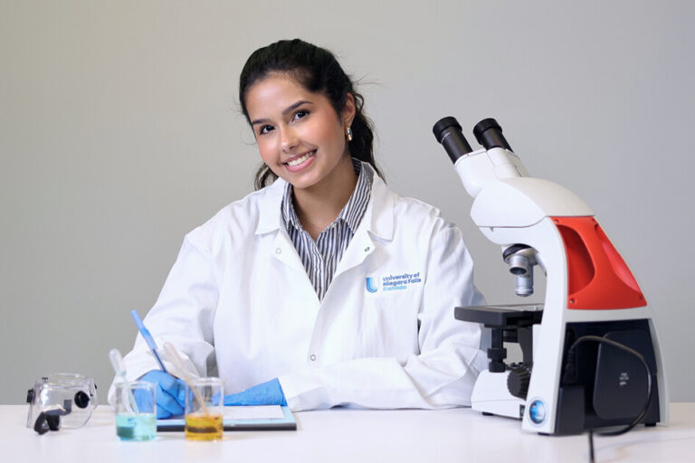 A medical student looking at camera while working on medical tools